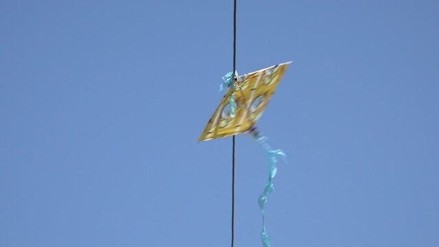 Kite stuck on wire being moved by wind, Banepa, Bagmati Province, Nepal