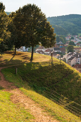 Tree and rounded hill form a tourist point of view of a European village: