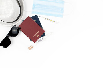 Top view or flat lay of travel accessories with hygienic mask and passport on blue white background with copy space, protection against corona virus or COVID-19 while traveling.