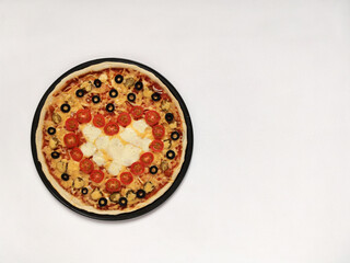 Pizza for Valentine's Day with red heart of cherry tomatoes. February 14 holiday concept with copy space