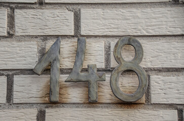 Schild mit einer Hausnummer -einhundertachtundvierzig  -148