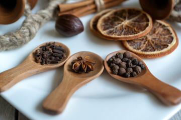 A set of various spices on wooden spoons and different surfaces.