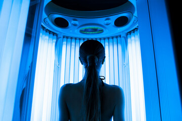 pretty woman or cute girl with sexy naked healthy body standing in solarium spa salon