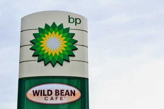  BP singboard, logo. BP and Wild Bean Cafe. BP plc (formerly The British Petroleum Company plc and BP Amoco plc). British multinational oil and gas company. Warsaw, Poland - October 26 2018