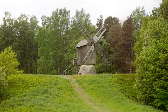 Wooden windmill on autumn forest hill. Timber construction - wildmill