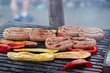 Sausage and vegetables are grilled over an open fire. Street food. BBQ picnic