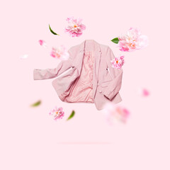 Creative Spring clothing concept. Womens fashionable flying pink blazer and delicate flowers...