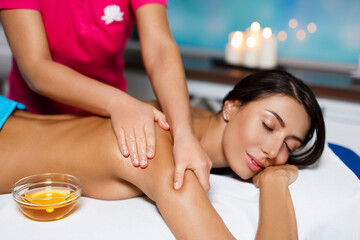 Obraz na płótnie Canvas Body massage and spa treatment in modern salon with candles. Body care concept, masseur hands close up