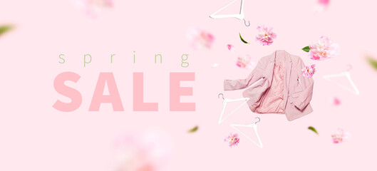 Spring sale Springtime discounts. Womens fashionable flying pink blazer flowers peonies white wooden hanger on pink background. Creative clothing concept shopping. Female stylish fabric cotton jacket