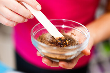 woman beautician masseur prepares natural body scrub in a glass cup. Natural cosmetics and skin care. Beauty treatments and relaxation.