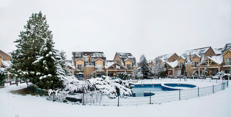 Obraz premium Snow covered yard with a pool in a beautiful neighborhood in Bucharest. Christmas background. Cold temperature, winter time