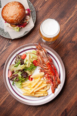 Dish of grilled shrimps and beer top view