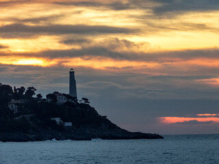 Lever de soleil sur la mer et le phare de la presqu'île du Cap Ferrat près de Nice sur la Côte...