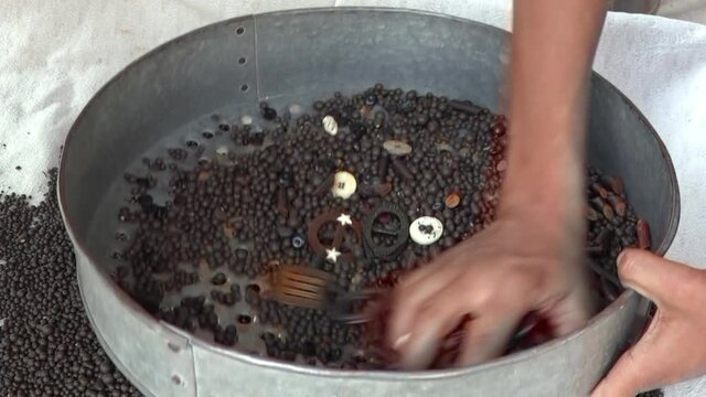 Man shaking buttons among beads for smoothing, Kathmandu, Bagmati Province, Nepal