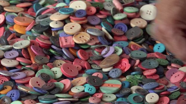 Woman working with pile of buttons, Kathmandu, Bagmati Province, Nepal