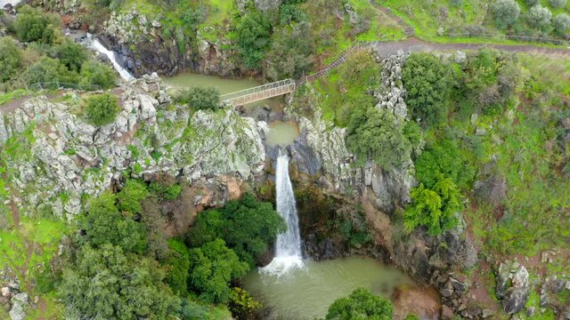 Saar Waterfall with Rain and Snow water plummeting down the stream, surrounded by lush green nature, Aerial view.
