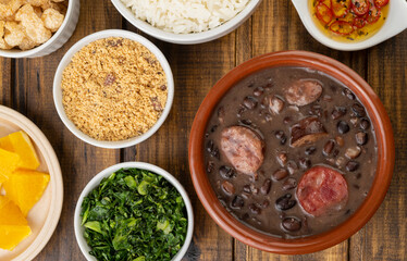 Traditional brazilian feijoada with orange, kale and manioc flour