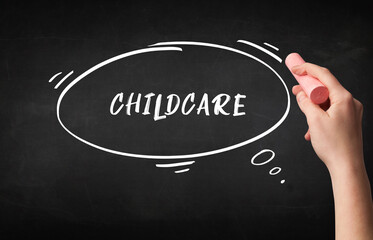 Hand drawing CHILDCARE inscription with white chalk on blackboard, education concept