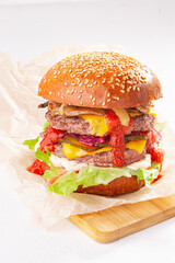 Double cheeseburger on the white background and wooden desk