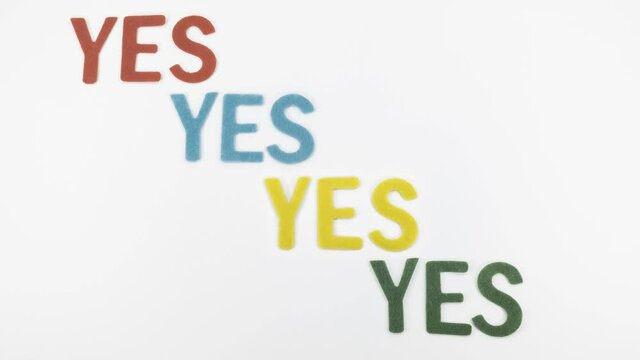 Animated stop motion video with banner YES that repeats four times in different colors: red, blue, yellow and green