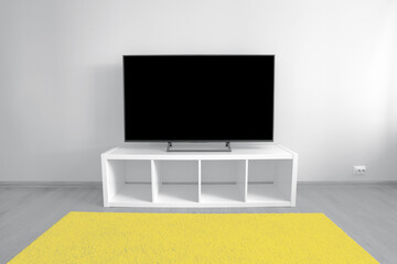 Lcd tv on white shef at modern room interior. Trendy colors of 2021 - Ultimate Gray and Illuminating