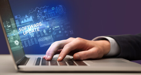 Obraz na płótnie Canvas Businessman working on laptop with SOFTWARE UPDATE inscription, cyber technology concept