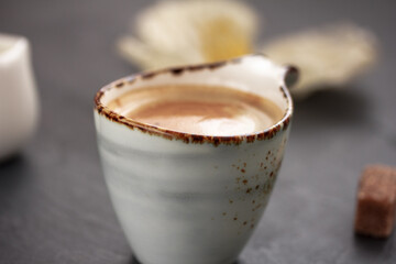 Closeup of beautiful grey coffee mug on dark grey background. Side view.