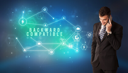 Businessman in front of cloud service icons with BACKWARD COMPATIBLE inscription, modern technology concept