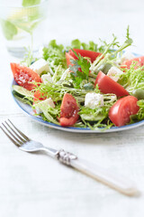 Salad with Green Olives, Tomatoes and Feta Cheese. Bright wooden background. Copy space.	