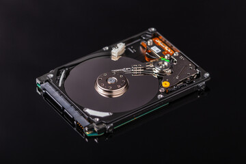 close-up of an open laptop hard drive on black mirror background