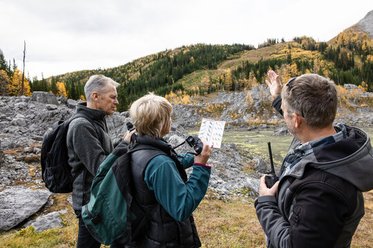 Trail Guide Helping Senior Bird Watchers In Autumn Mountain