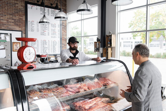 Customer making selection from meat counter in butcher's shop
