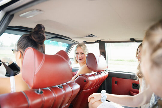 Happy Teenage Girl Friends Riding In Car