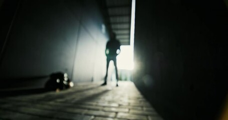 Silhouette of a young athlete guy on the street with a sports bag in sportswear preparing for a workout serious portrait look into the camera