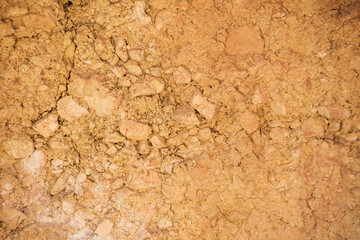 rocky dry ground with cracks of terracotta color, texture. 