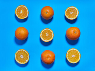 Whole and split oranges on a blue background. CITRUS CITRIC