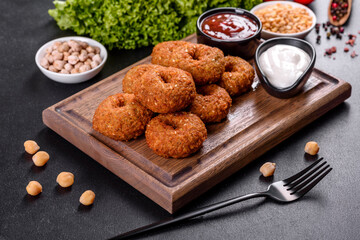 Beautiful delicious fresh chickpea falafel with sauces on a concrete background