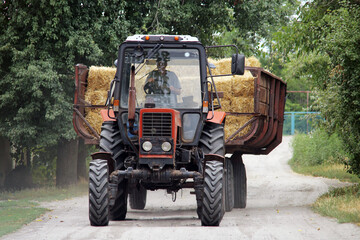 Fototapeta premium tractor with trailer transporting straw
