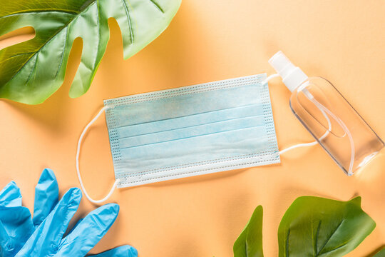 Face mask and antiseptic at beige pastel background. Creative layout. New normal concept.