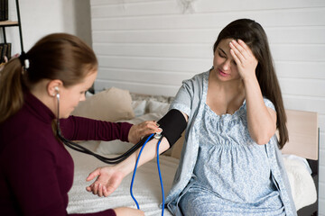 Measuring the pressure of a pregnant woman at home. Poor well-being of a pregnant woman.