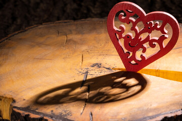 red heart with a pattern on a cracked sawn tree with bark