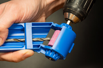 Sharpening a drill on a sharpener with a drill