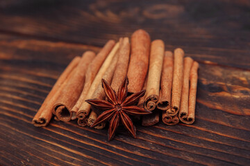 Cinnamon sticks and star anise close-up on a brown wooden table close-up, cooking and drink concept, Christmas mulled wine and pastries, spices, seasonings and health