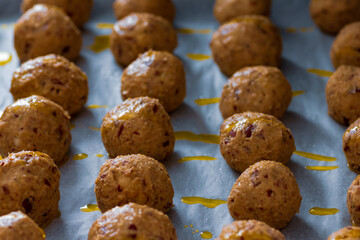 Falafel roh in Reihe auf einem Backpapier mit Öl