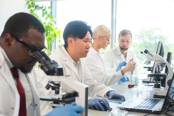 Scientist working in lab. Doctors making medical research. Biotechnology, chemistry, science, experiments and healthcare concept. Day light and window background.