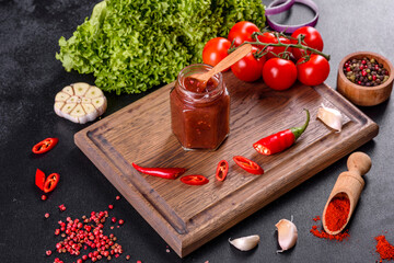 Spicy seasoning of Georgian cuisine adjika in a bowl with red pepper and garlic