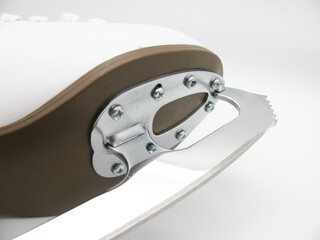 The sole, the blade of a white figure skate. Front part.
