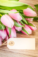 Obraz na płótnie Canvas pink tulips with empty tag