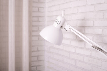 Small table lamp in beauty studio on white brick background