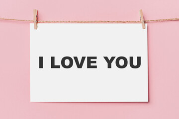 note letter pin on rope on pink background, love and valentine concept I love you
